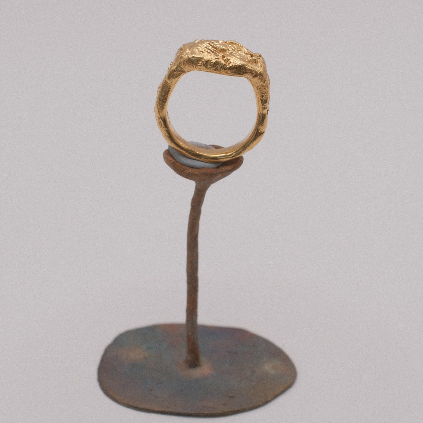 18k gold ATLANTIS ring on a metal stand