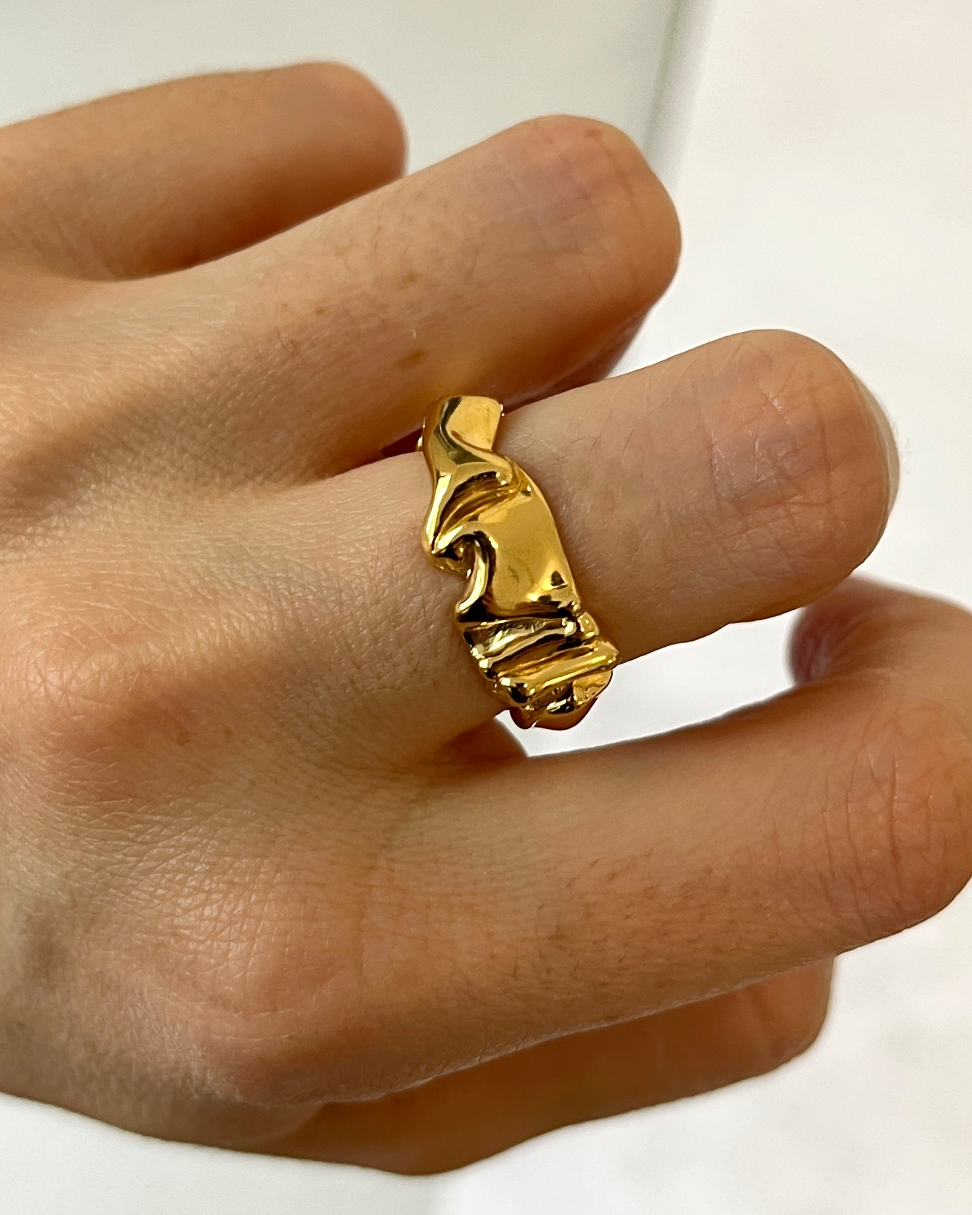 gold OVIS organic band ring on a finger 